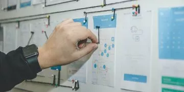 Man pinning notepads on a project board