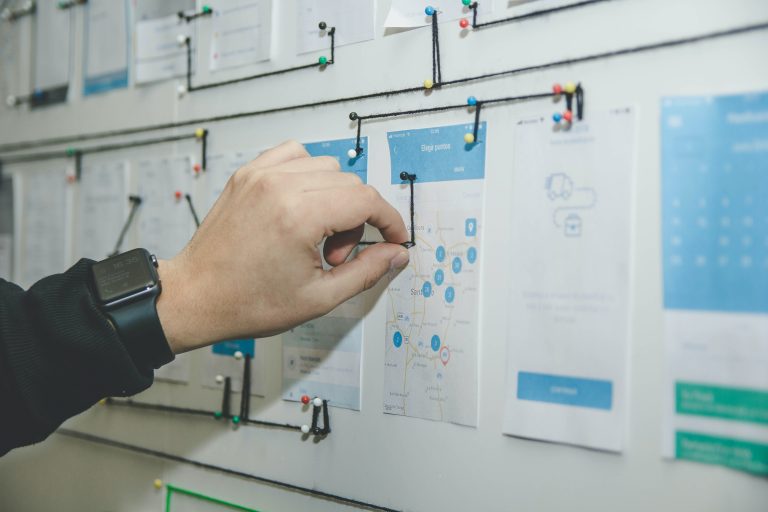 Man pinning notepads on a project board